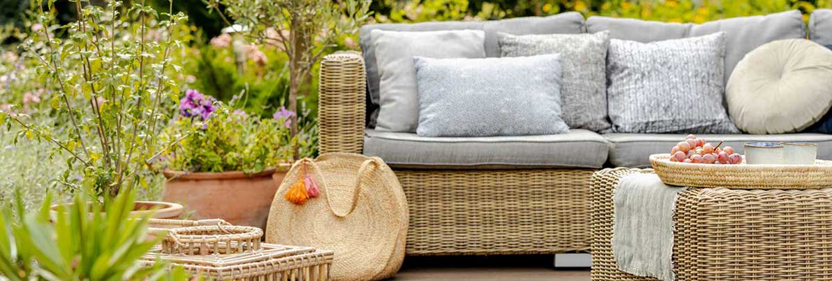 outdoor furniture surrounded by lots of plants in pots.