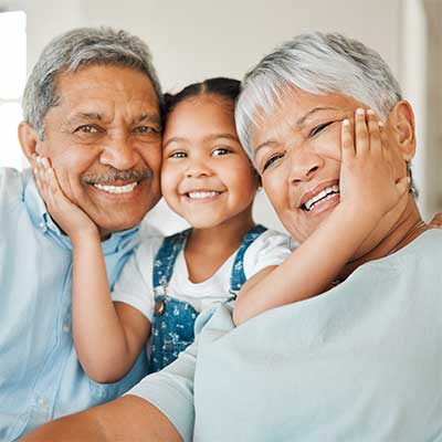senior hispanic couple playing with young child.