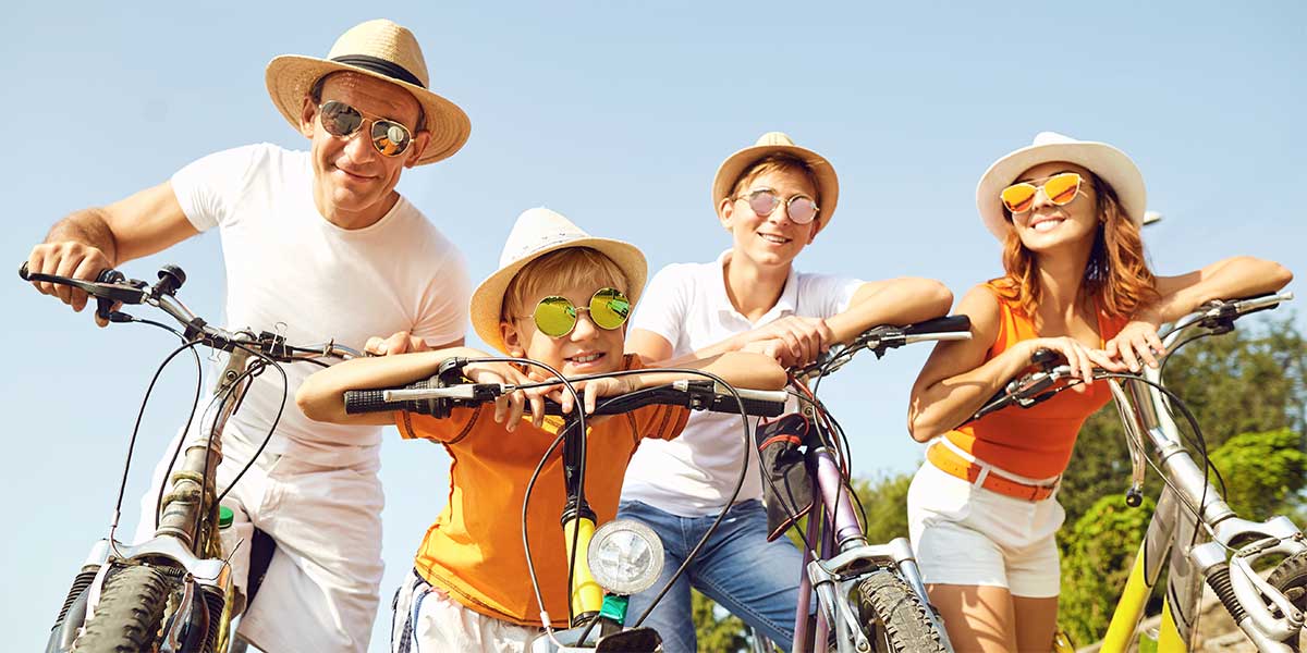 family of 4 on bikes wearing sunglasses.