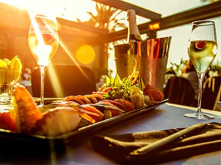 tapas and 2 glasses of champaign with sunlight shining through glasses.