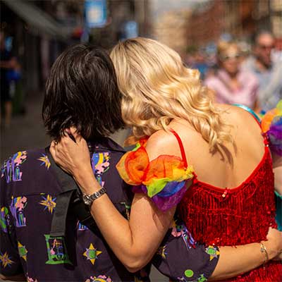 two women from behind holding hands.