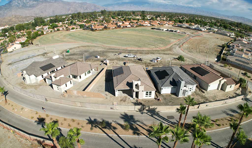 aerial drone view of Palazzo homes with mountains in background.