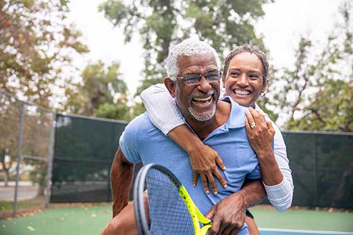 African American couple on tennis court.